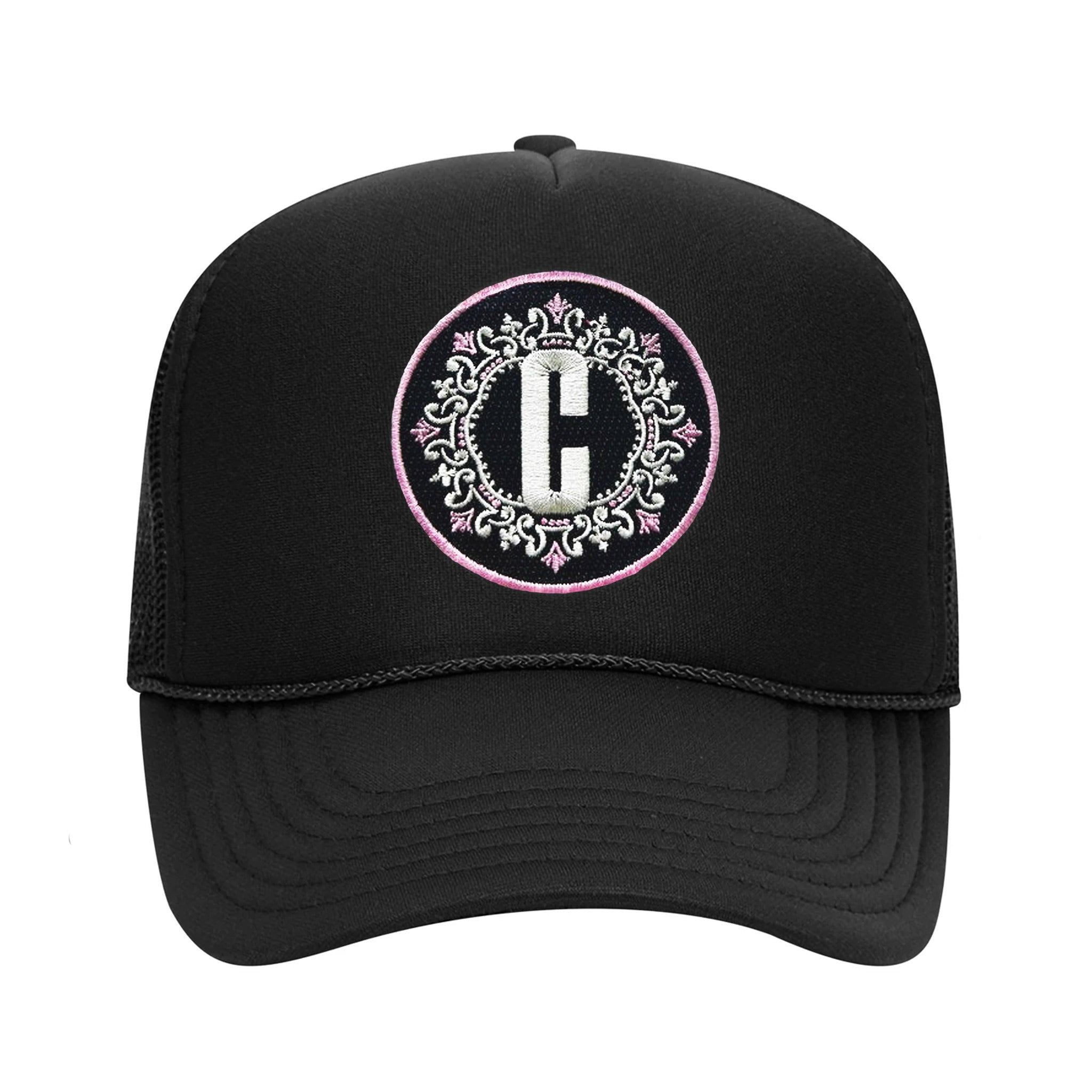 Celleste "C" logo Trucker hat with embroidered black, white and pink patch. Front view.